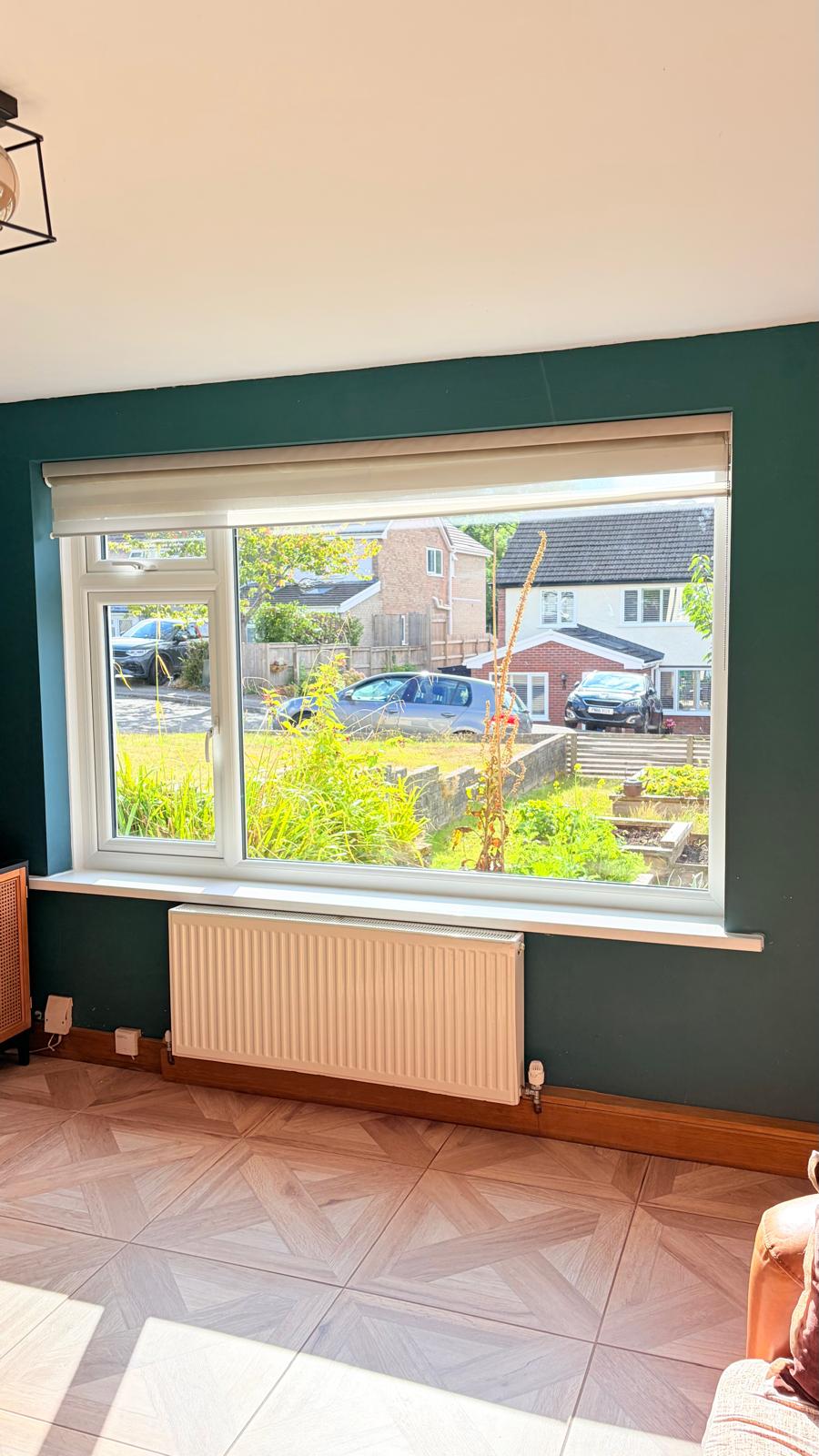 Wide white PVCu living room window with opening casement overlooking the garden