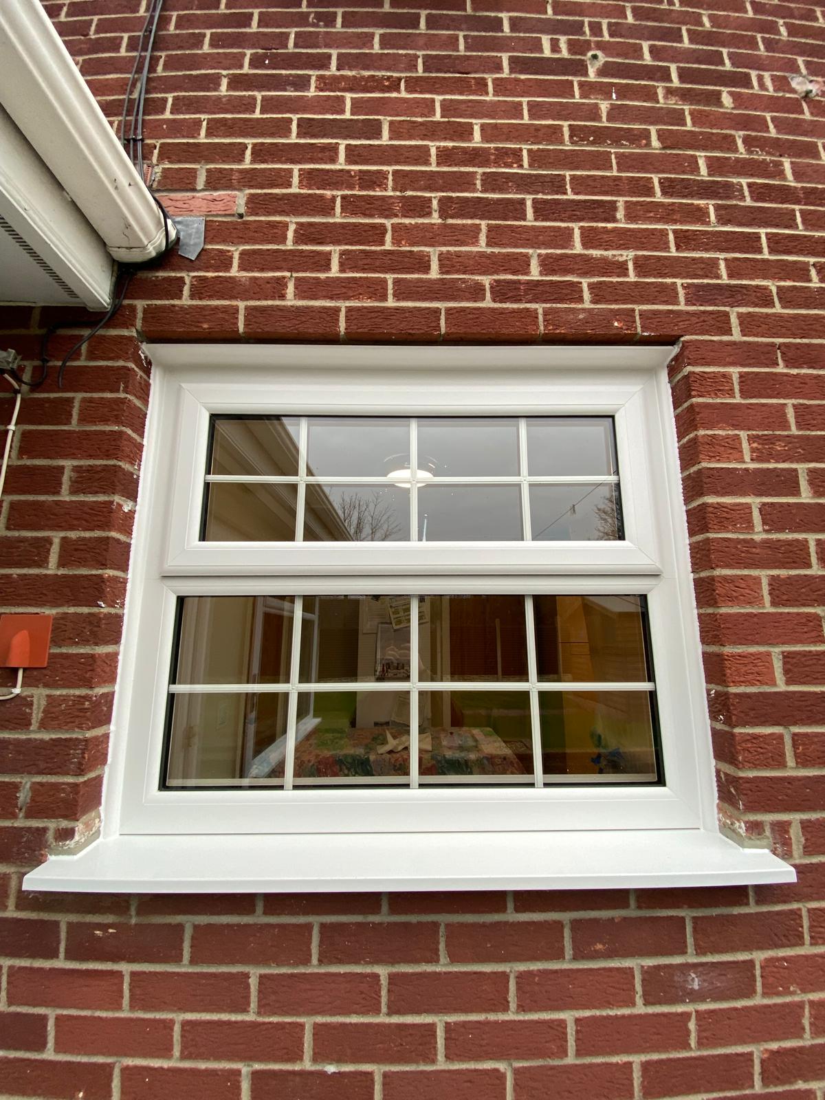 White PVCu casement window with Georgian bar glazing in red brickwork